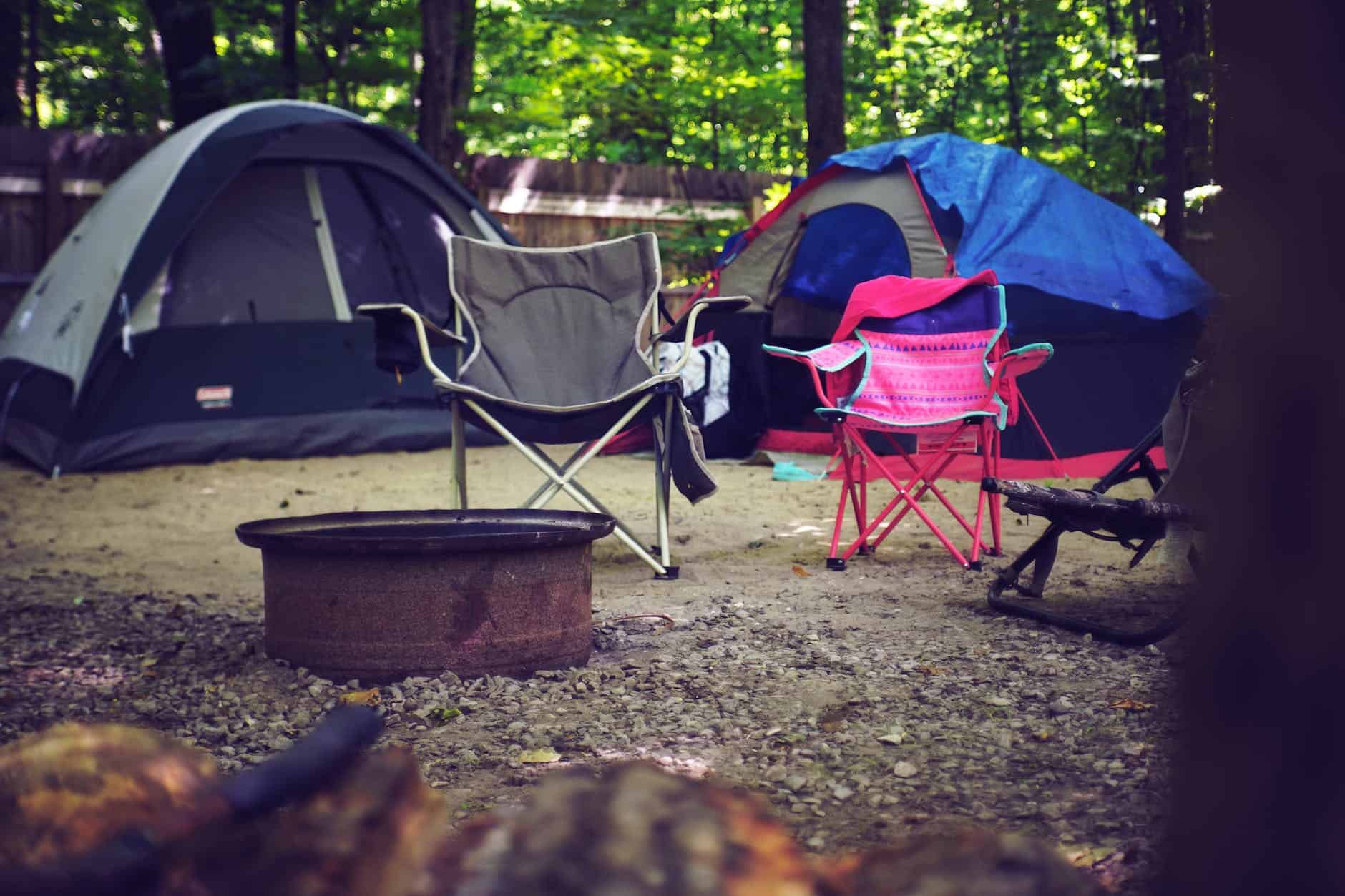 two pink and gray camping chairs at a campsite. fall camping with kids.